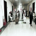 عسير - أحد طلاب جامعة الملك خالد يلتقط صورة لطلاب يختبرون في احد الممرات