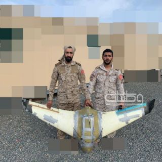 "الشهري" والبارقي" يلتقطان صورة وهم يحملان طائرة مسيرة تم إسقاطها