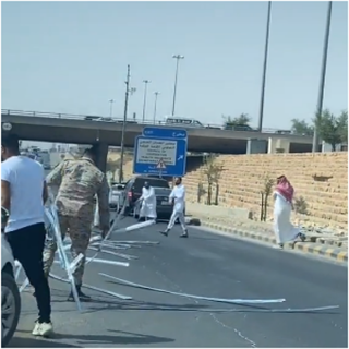 فيديو -عدد من المارة يرفعون مخلفات حمولة ناقلة سقطت على الطريق